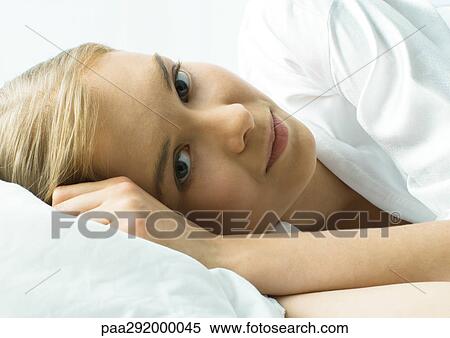 Young woman lying in bed, close-up View Large Photo Image Stock Photography - Young woman lying in bed, close-up. Fotosearch