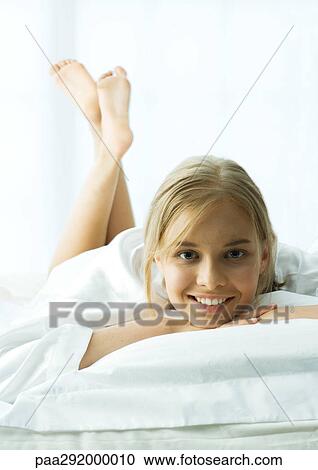 Young woman lying on stomach with legs up View Large Photo Image Stock Image - Young woman lying on stomach with legs up. Fotosearch
