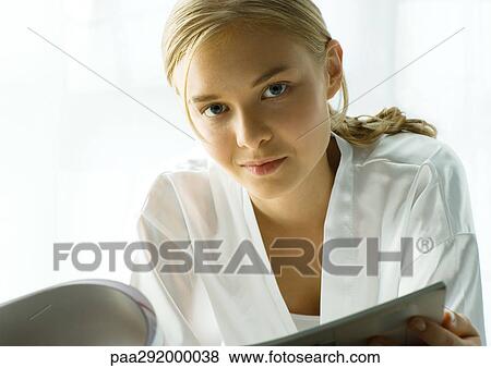 Stock Photo - Young woman with magazine. Fotosearch