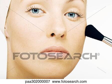 Stock Photo - Woman applying blush, close-up. Fotosearch