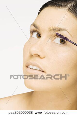 Stock Photo - Woman applying mascara. Fotosearch