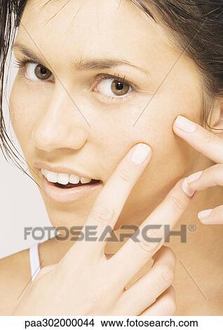 Woman touching cheek, close-up View Large Photo Image Picture - Woman touching cheek, close-up. Fotosearch