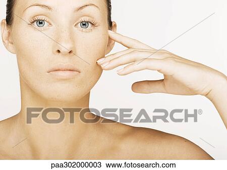 Stock Image - Woman touching face. Fotosearch