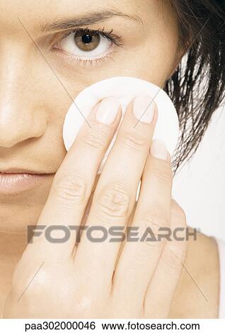 Woman using cotton pad on face, close-up View Large Photo Image Stock Photograph - Woman using cotton pad on face, close-up. Fotosearch