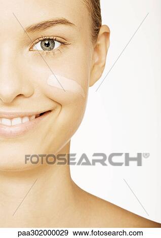 Stock Photo - Woman's face with foundation on cheek, partial view. Fotosearch