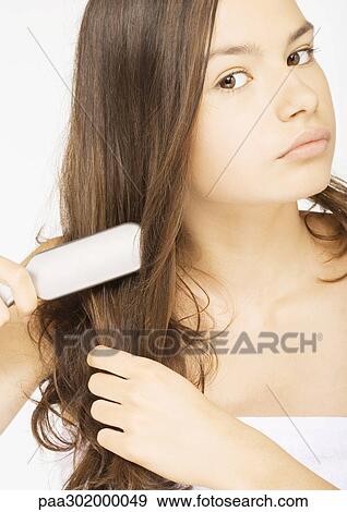 Young woman brushing hair View Large Photo Image Stock Photo - Young woman brushing hair. Fotosearch