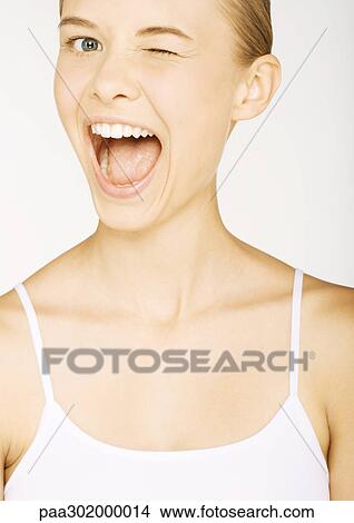 Young woman in tank top winking, portrait View Large Photo Image Picture - Young woman in tank top winking, portrait. Fotosearch