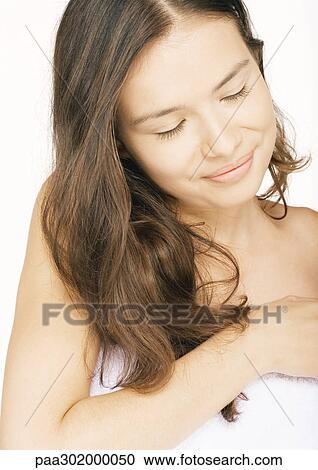 Young woman in towel with eyes closed, portrait View Large Photo Image Stock Image - Young woman in towel with eyes closed, portrait. Fotosearch