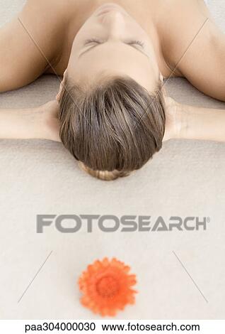Flower and woman lying with hands behind head View Large Photo Image Stock Image - Flower and woman lying with hands behind head. Fotosearch