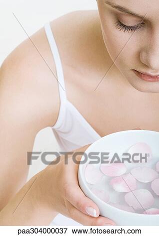 Woman holding bowl of rose petals floating in water View Large Photo Image Stock Photo - Woman holding bowl of rose petals floating in water. Fotosearch