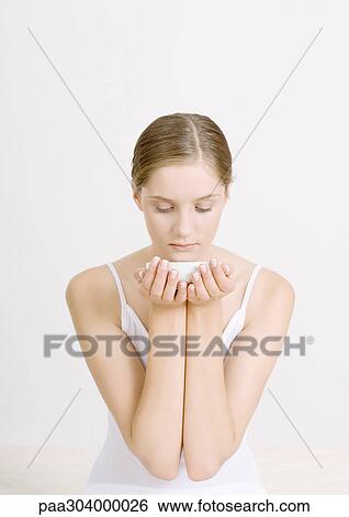 Woman holding up bowl under chin, looking down View Large Photo Image Stock Photograph - Woman holding up bowl under chin, looking down. Fotosearch