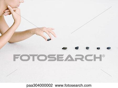 Woman placing stones in line View Large Photo Image Stock Image - Woman placing stones in line. Fotosearch