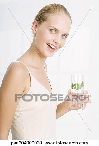 Woman smiling and holding glass of herb water View Large Photo Image Stock Photo - Woman smiling and holding glass of herb water. Fotosearch