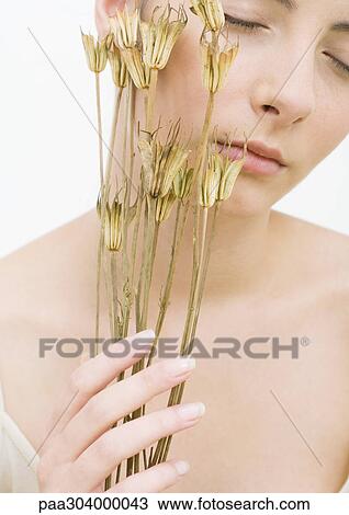 Woman with eyes closed holding dried flowers against face View Large Photo Image Stock Image - Woman with eyes closed holding dried flowers against face. Fotosearch
