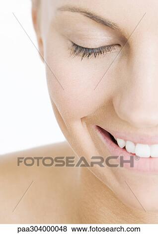 Stock Photo - Woman with eyes closed smiling, close-up. Fotosearch