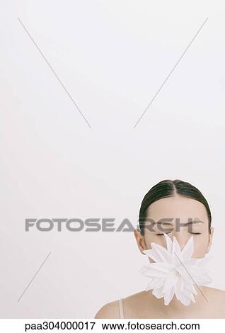 Woman with flower in mouth and eyes closed View Large Photo Image Stock Photo - Woman with flower in mouth and eyes closed. Fotosearch