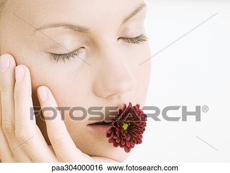 Woman with flower in mouth and eyes closed View Large Photo Image Stock Photograph - Woman with flower in mouth and eyes closed. Fotosearch