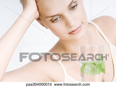 Stock Photography - Woman with glass of herb water. Fotosearch