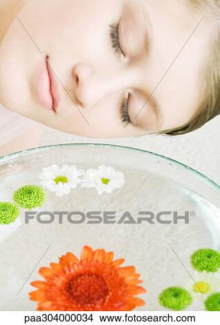 Woman's face and bowl of flowers floating in water View Large Photo Image Picture - Woman's face and bowl of flowers floating in water. Fotosearch