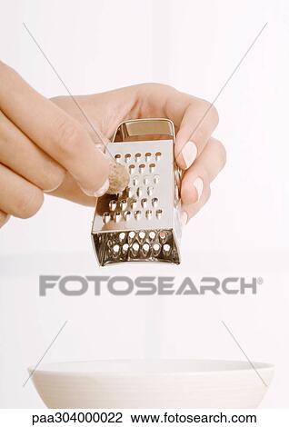 Woman's hand grating nutmeg into bowl View Large Photo Image Stock Image - Woman's hand grating nutmeg into bowl. Fotosearch