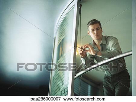 Businessman leaning on rail, low angle view View Large Photo Image Stock Photo - Businessman leaning on rail, low angle view. Fotosearch