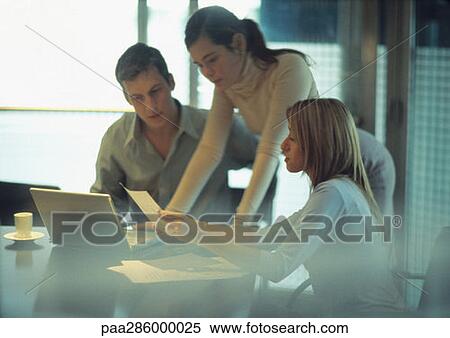 Businesspeople looking at document View Large Photo Image Stock Photography - Businesspeople looking at document. Fotosearch
