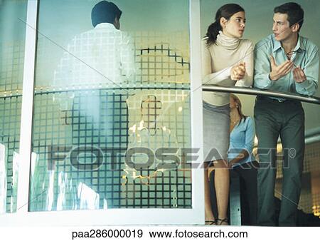 Stock Photo - Businesspeople talking in conference room, low angle view. Fotosearch