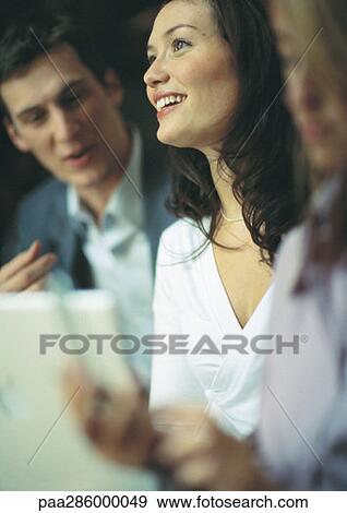 Businesswoman smiling between two co-workers View Large Photo Image Stock Photo - Businesswoman smiling between two co-workers. Fotosearch