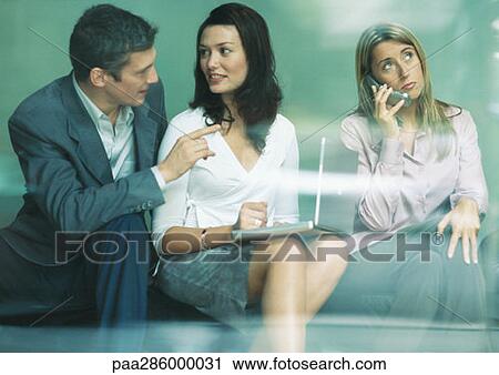 Three businesspeople using laptop and cell phone View Large Photo Image Stock Image - Three businesspeople using laptop and cell phone. Fotosearch
