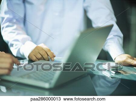 Two men using laptop View Large Photo Image Stock Image - Two men using laptop. Fotosearch