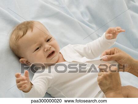 Stock Image - Baby being dressed. Fotosearch