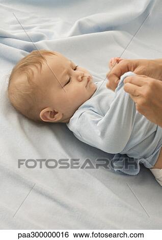 Stock Photograph - Baby being dressed. Fotosearch