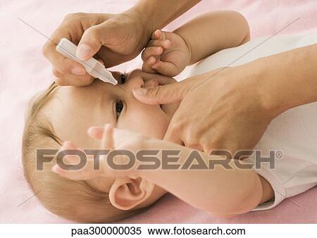 Baby having eyes cleaned View Large Photo Image Stock Photography - Baby having eyes cleaned. Fotosearch