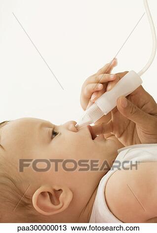 Stock Image - Baby having nose cleaned out. Fotosearch