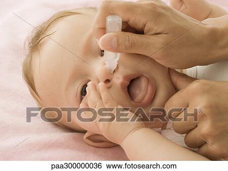 Baby having nose cleaned View Large Photo Image Stock Photograph - Baby having nose cleaned. Fotosearch