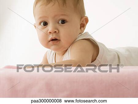 Baby lying on stomach, holding head up View Large Photo Image Stock Photo - Baby lying on stomach, holding head up. Fotosearch