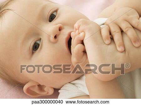 Stock Image - Baby putting foot in mouth. Fotosearch