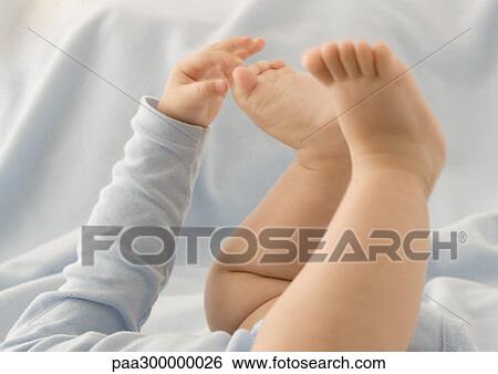 Baby touching his feet, close-up of arm and legs View Large Photo Image Stock Photograph - Baby touching his feet, close-up of arm and legs. Fotosearch