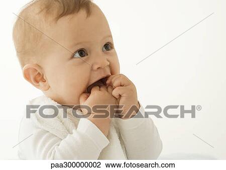 Stock Image - Baby with hands in mouth. Fotosearch