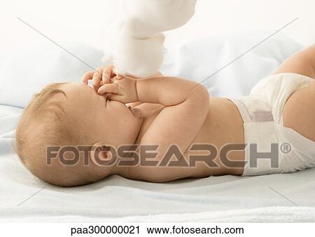 Baby with toy, covering face and laughing View Large Photo Image Stock Image - Baby with toy, covering face and laughing . Fotosearch