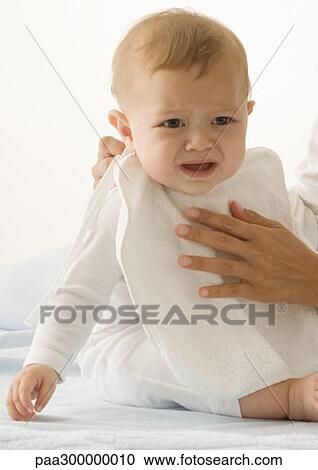 Stock Image - Putting bib on baby. Fotosearch