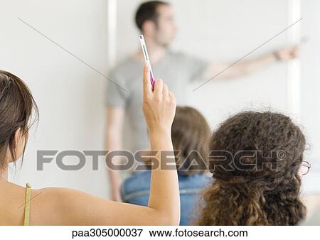 Female student raising hand in class View Large Photo Image Stock Photo - Female student raising hand in class. Fotosearch