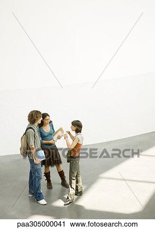 Group of students standing together, talking in lobby View Large Photo Image Stock Image - Group of students standing together, talking in lobby. Fotosearch