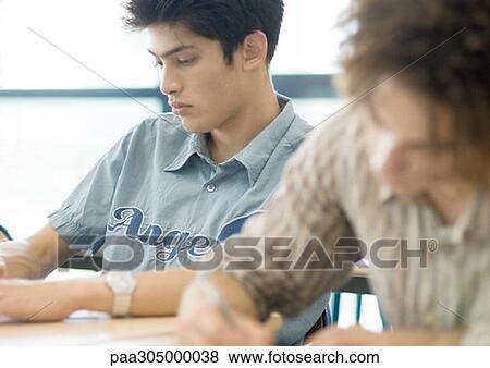 Two male students writing in class View Large Photo Image Stock Photo - Two male students writing in class. Fotosearch