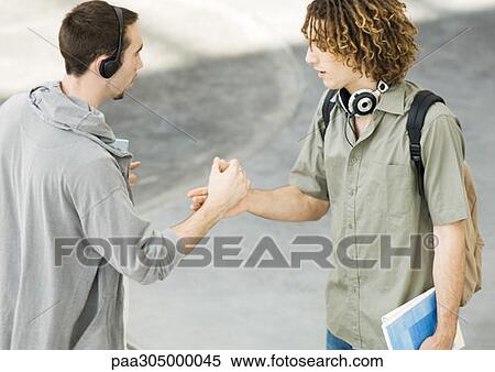 Two young men shaking hands View Large Photo Image Stock Photography - Two young men shaking hands. Fotosearch