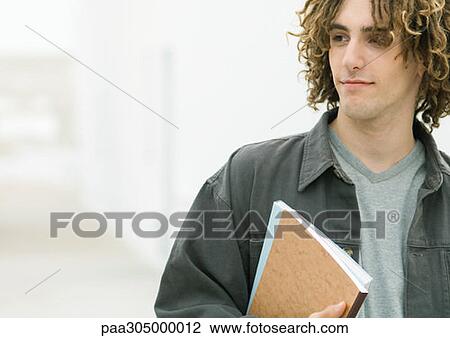Young man holding notebooks View Large Photo Image Stock Image - Young man holding notebooks. Fotosearch