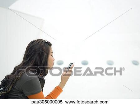 Young woman looking at cell phone View Large Photo Image Stock Photography - Young woman looking at cell phone. Fotosearch