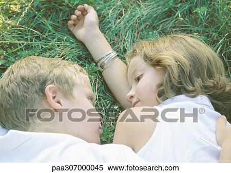 Boy and girl lying in grass View Large Photo Image Stock Photography - Boy and girl lying in grass. Fotosearch