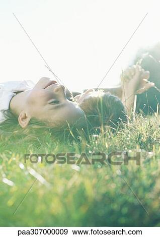 Stock Photo - Boy and girl lying on grass together. Fotosearch