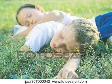 Boy and girl sleeping in grass View Large Photo Image Stock Image - Boy and girl sleeping in grass. Fotosearch